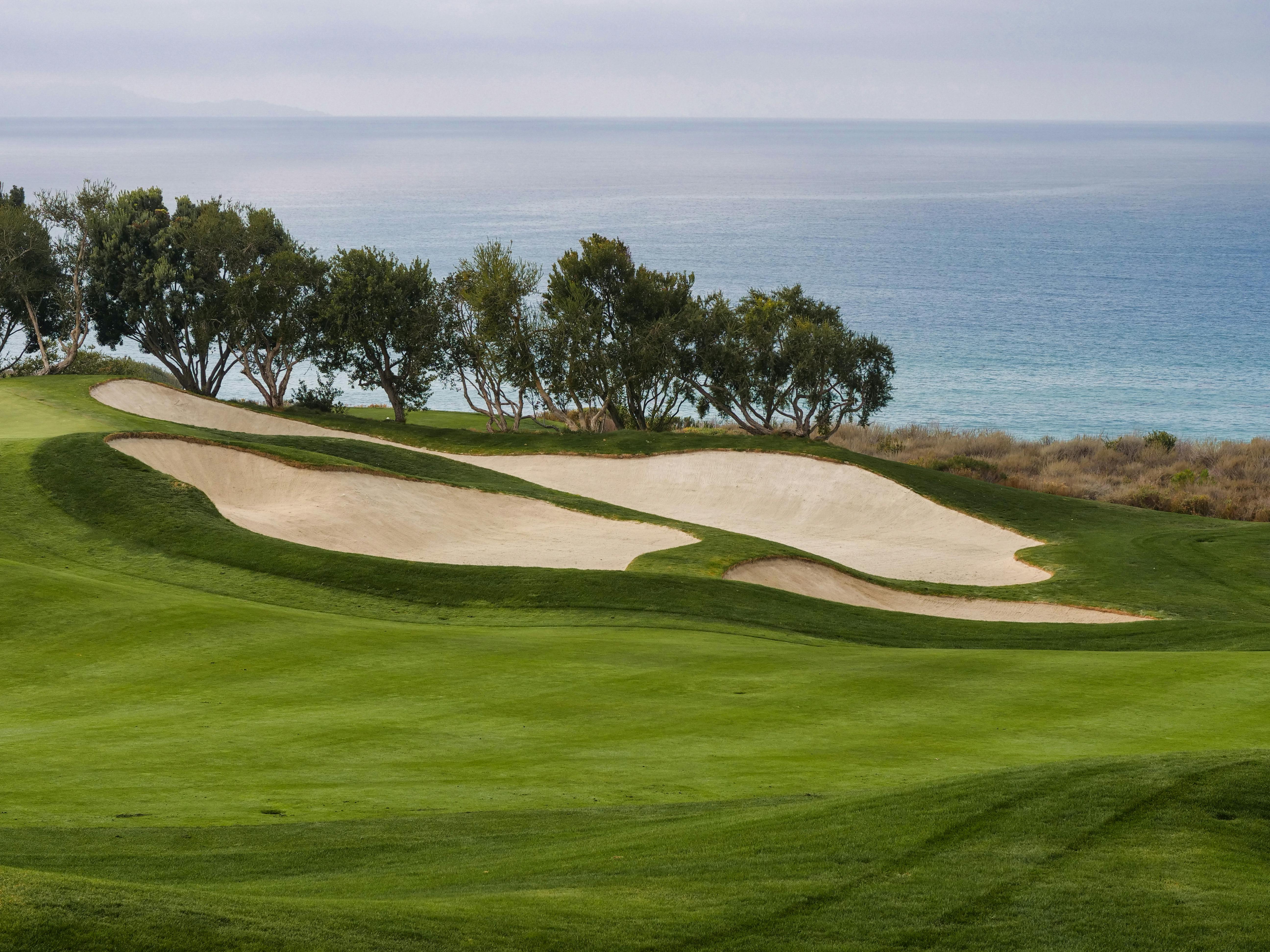 Golf course with sand bunkers and ocean view